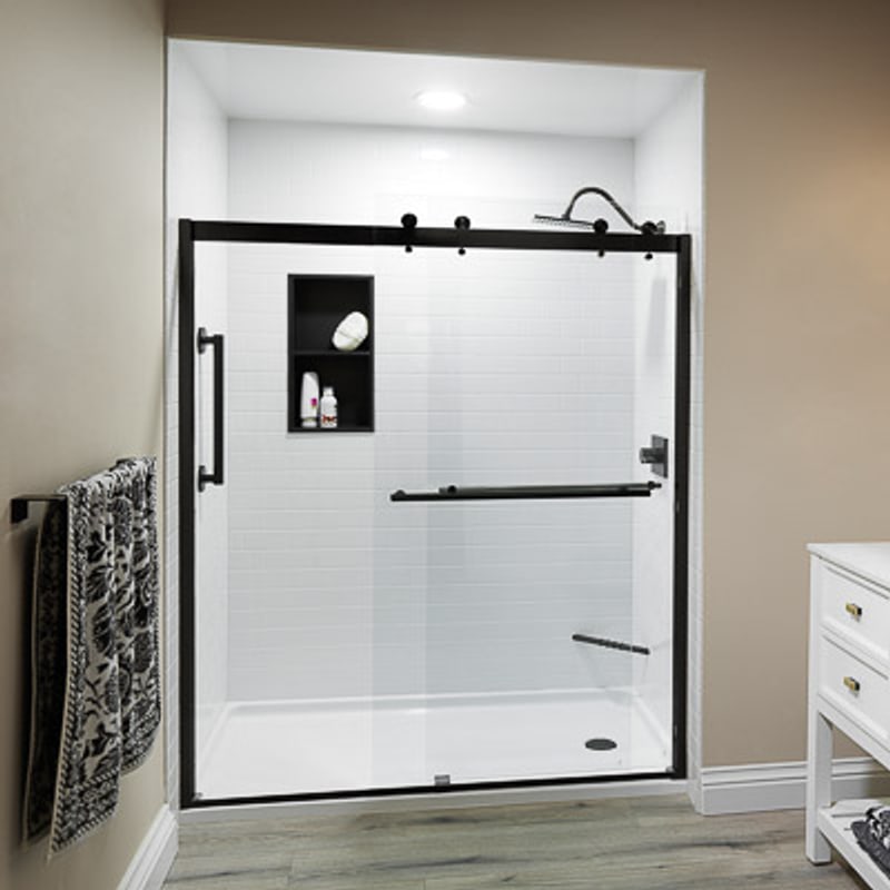 Frameless sliding glass shower door with matte black hardware